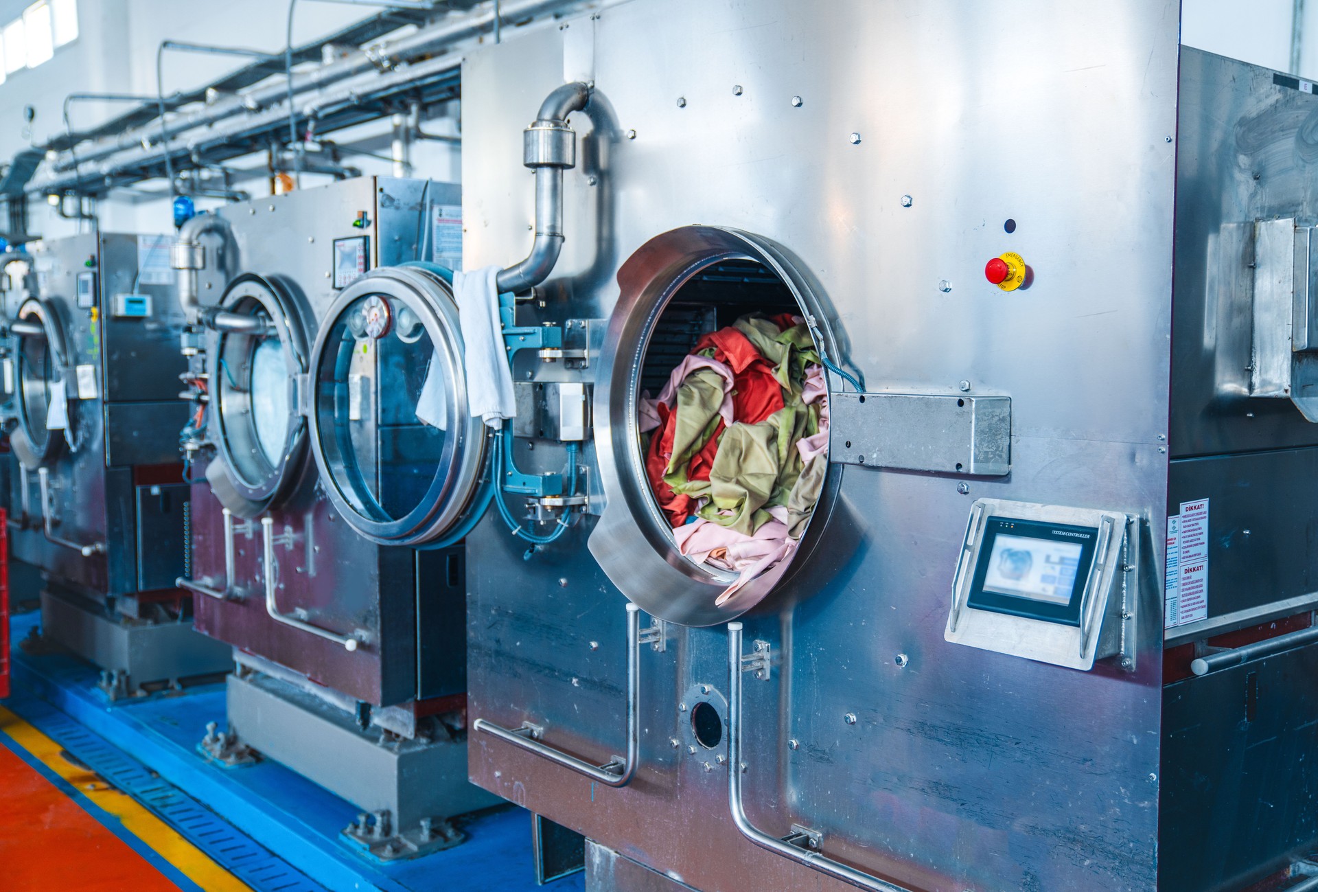 Industrial automatic washing machines at laundry service stock photo.